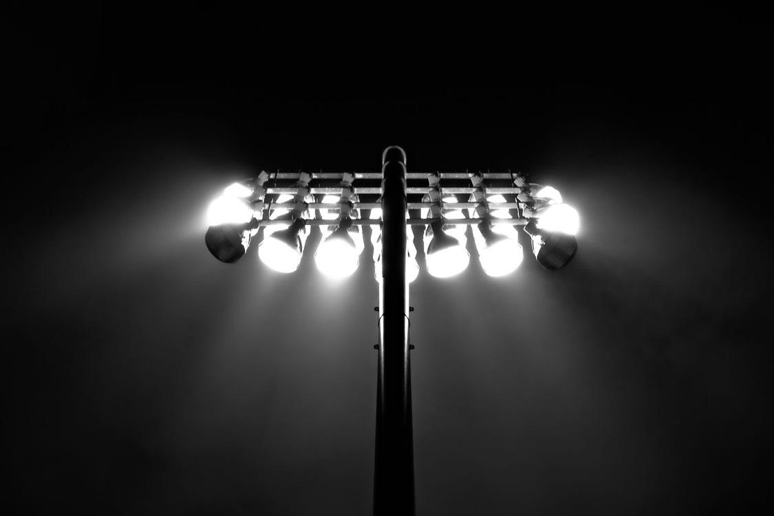 Projecteurs de stade allumés dans la nuit, en noir et blanc