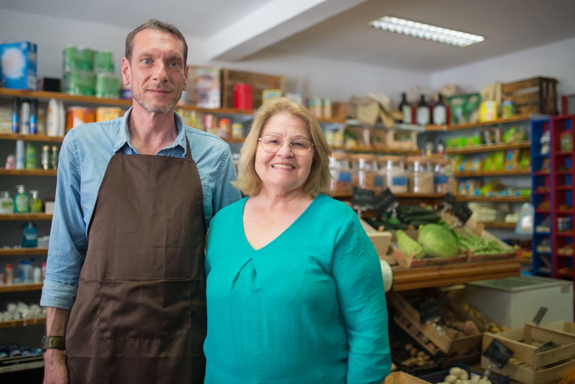 Couple échangeant avec le commerçant dans une boutique de proximité