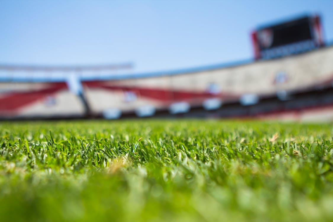 Stade de sport vide avec pelouse entretenue vu depuis les tribunes