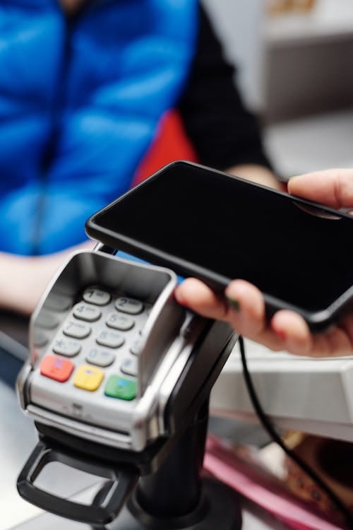 Client utilisant son smartphone pour un paiement sans contact en boutique