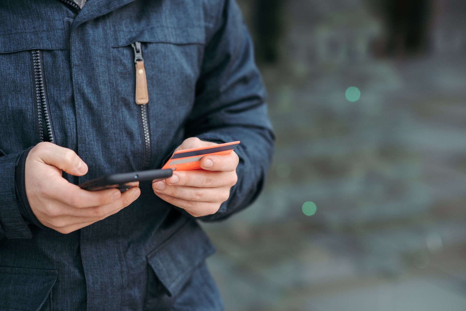 Client utilisant une appli mobile sur son smartphone en pleine rue commerçante