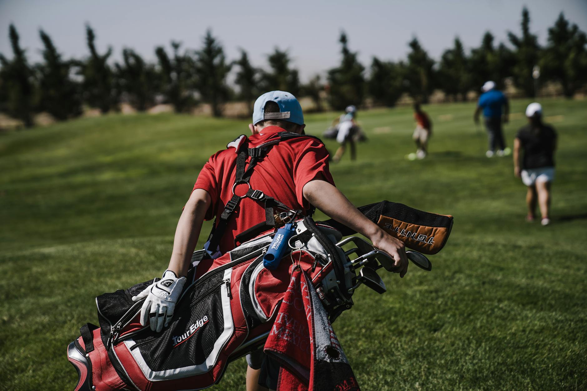 Golfeur marchant sur un parcours verdoyant avec son sac de golf