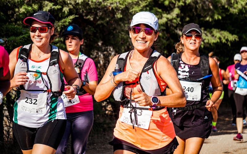 Groupe de coureuses souriantes participant à un marathon en plein air