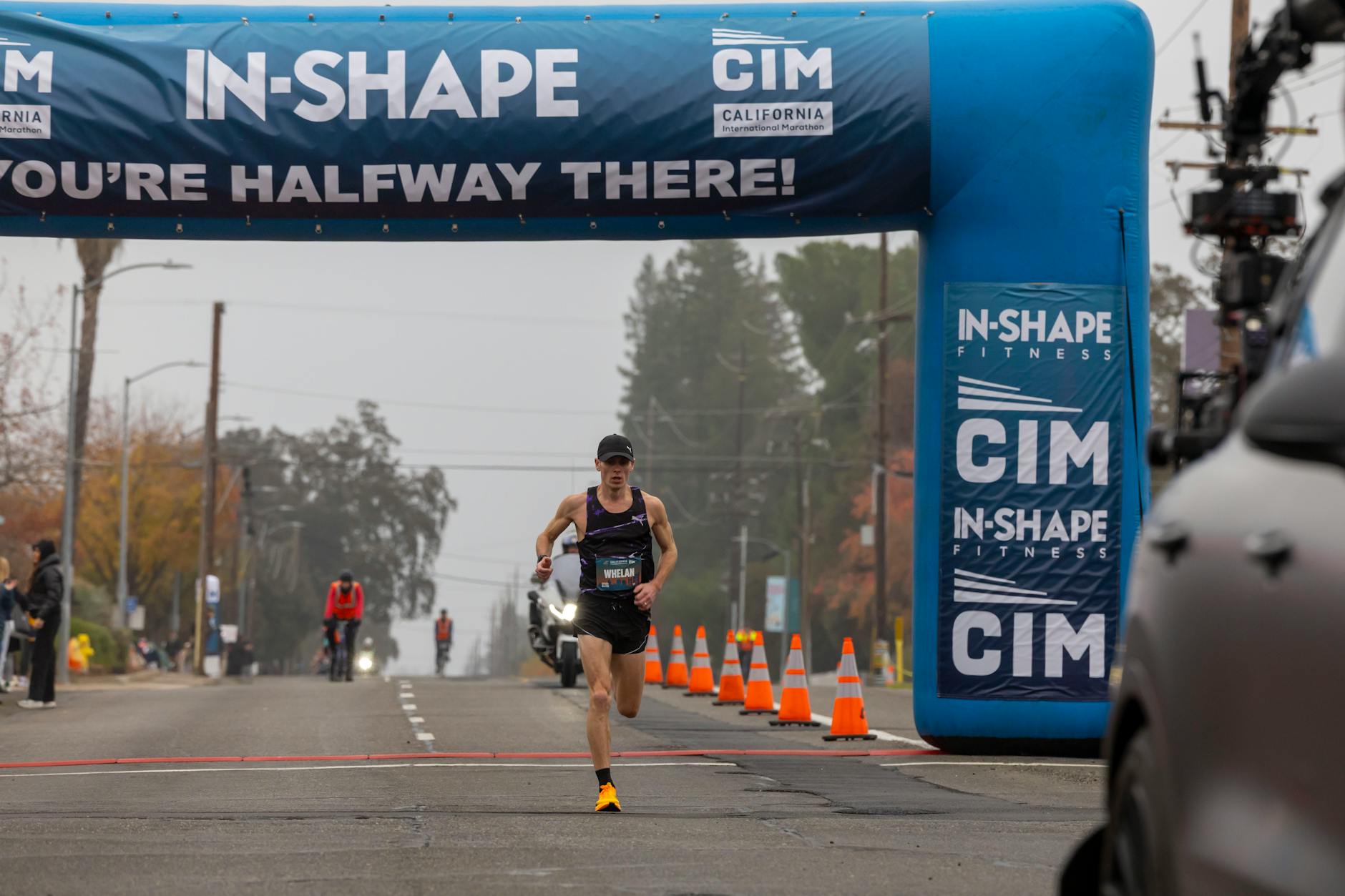 Coureur de marathon passant un point de contrôle sur un parcours balisé